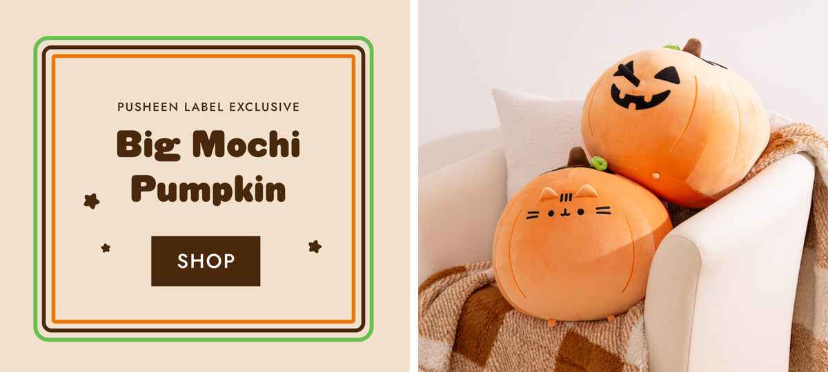 Two large Pusheen Pumpkin plush stacked on top of a chair. One side of the plush has a jack-o-lantern face and the other side has Pusheen the Cat's face.