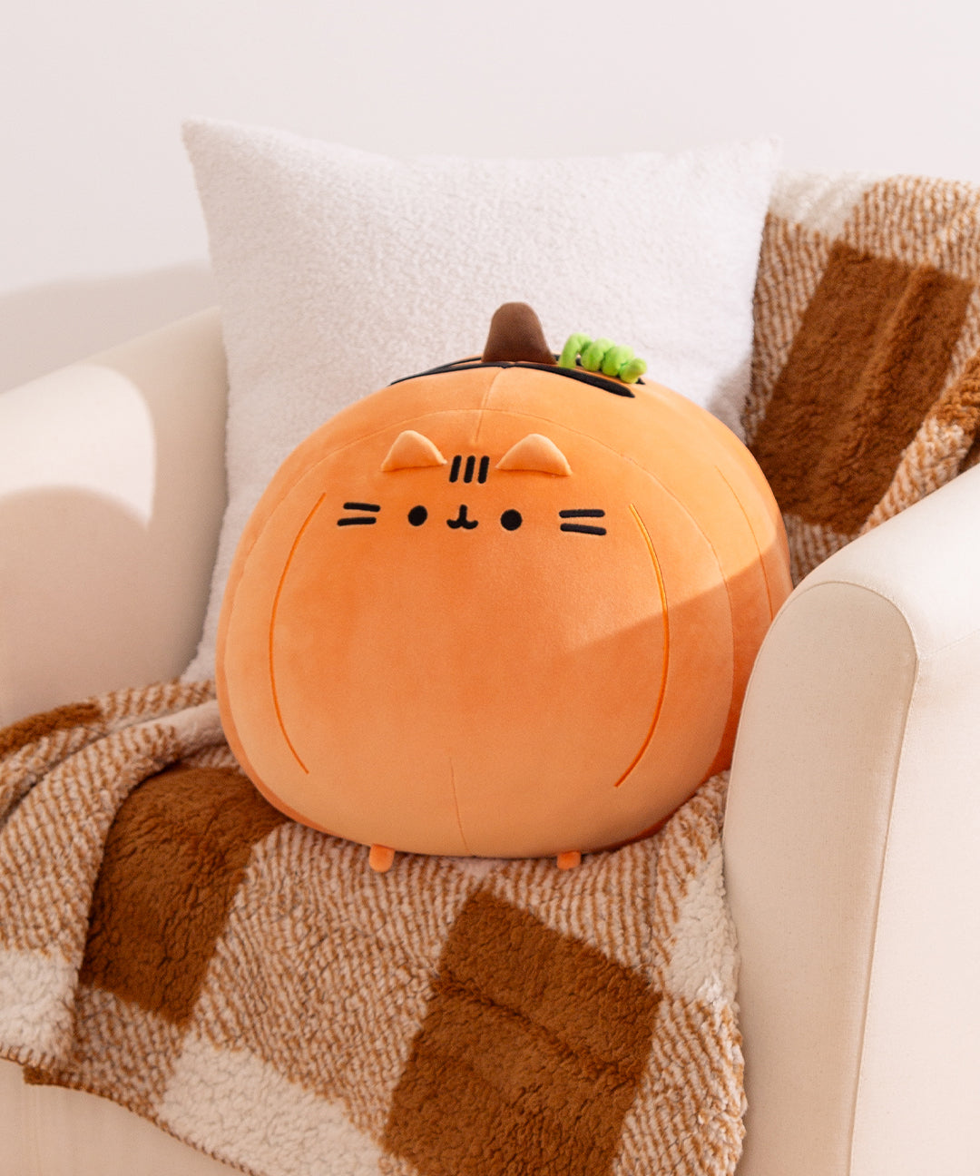 Large big mochi pumpkin Pusheen Plush shows Pusheen as an orange pumpkin with embroidered details and a 3D stem and curly vine at the top of the plush.