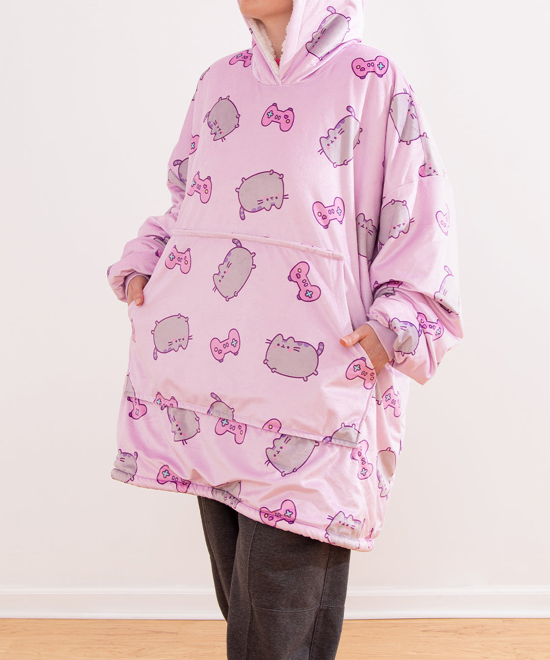Model wears a Gamer Blanket Hoodie. With the sleeves scrunched up, the model has their hands in the front pocket to show the size and scale of the front pocket.