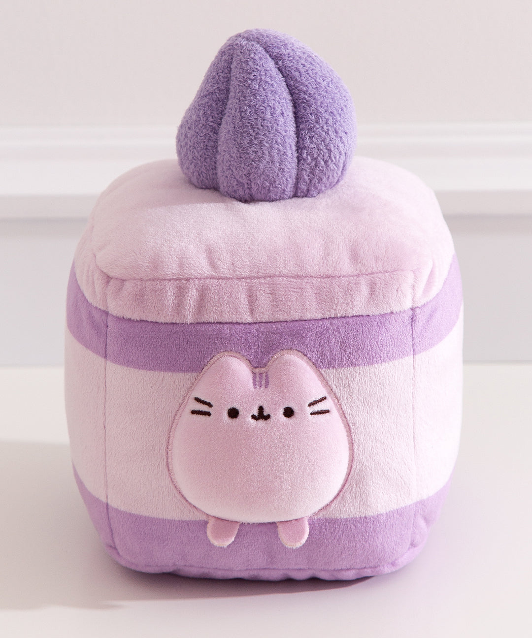 Close-up of the Pusheen figure within the plush cake and cream layers. Pusheen the Cat's two front paws sit outside of the cream layer.