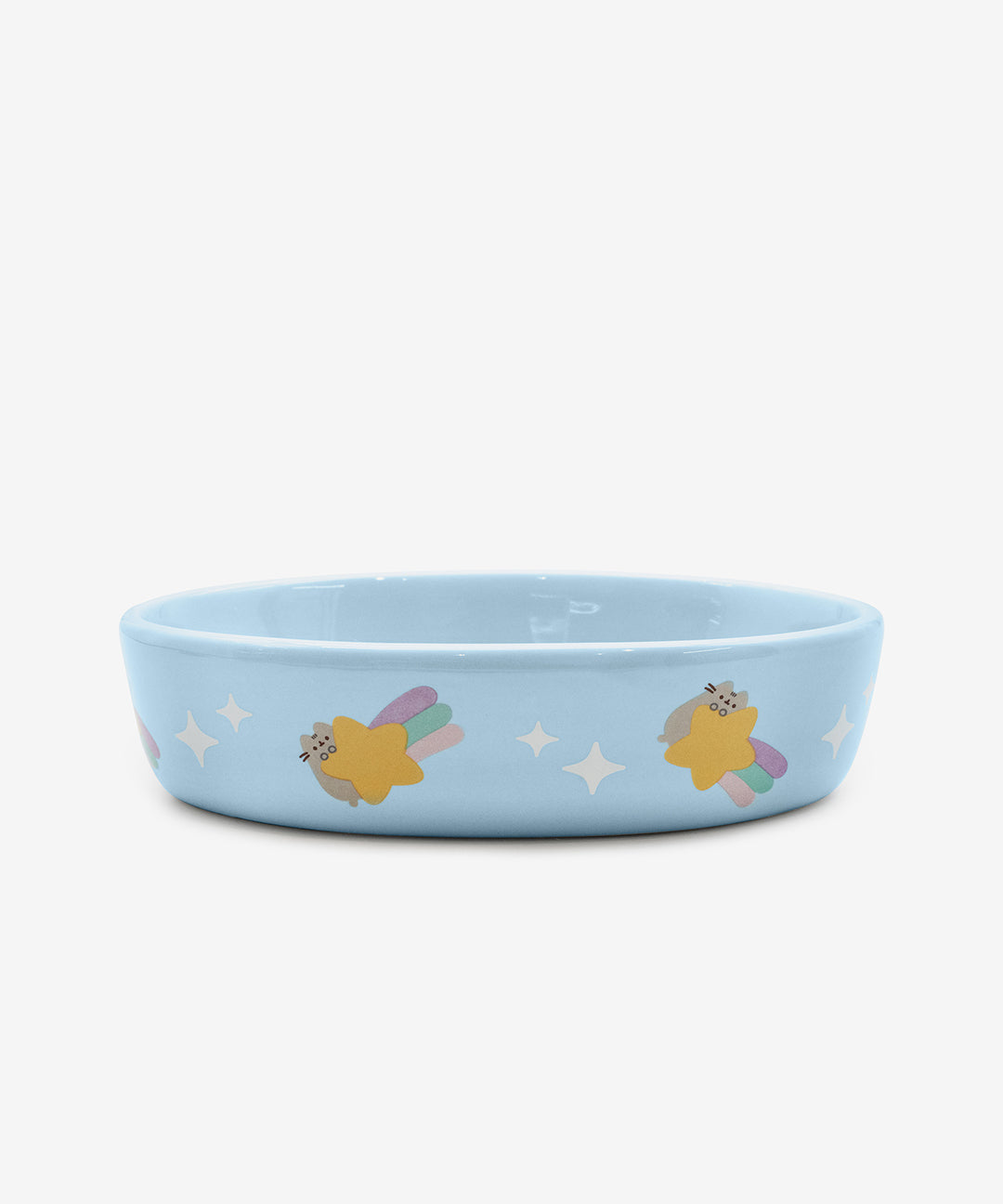 The Pusheen Pet Blue Bowl has a Pusheen print on the outer edge of the  blue ceramic pet bowl. The print features a repeating pattern of Pusheen holding a multi-color shooting star next to white stars.