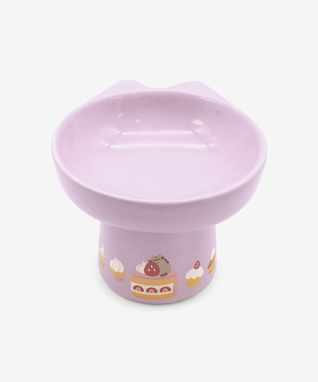 Pastel purple Pusheen Pet Pedestal Bowl has a round bowl with two cat ears at the top of the bowl. The bottom of the stand has a repeating print of Pusheen the Cat with strawberry and vanilla desserts.