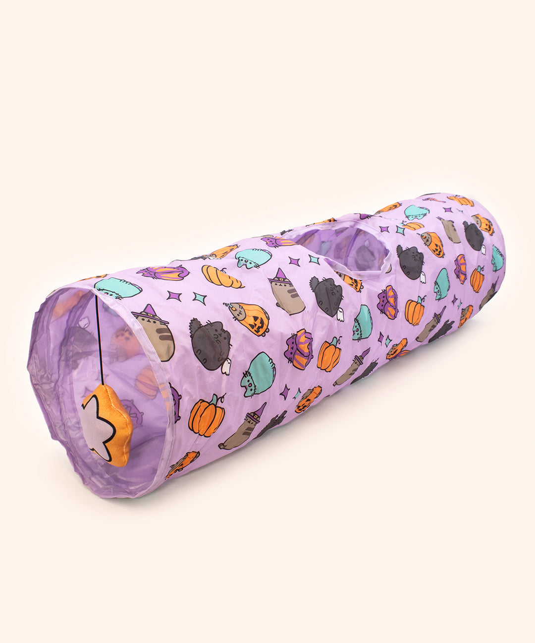 Full view of the Pusheen Pet Purple Halloween Collapsible Tunnel. The long tunnel has a rounded opening on both ends and a surprise circle opening in the top middle of the tube. One opening has a dangling plush of a star.