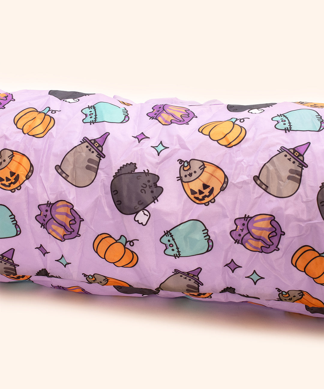 Close-up of the pattern on the Pet Collapsible Tunnel. The pattern includes an all over print of different Pusheen Halloween characters including Scaredy Cat, Pumpkin Pusheen, Witch Pusheen, Batsheen, and Zombiesheen. The background of the print is light purple. 