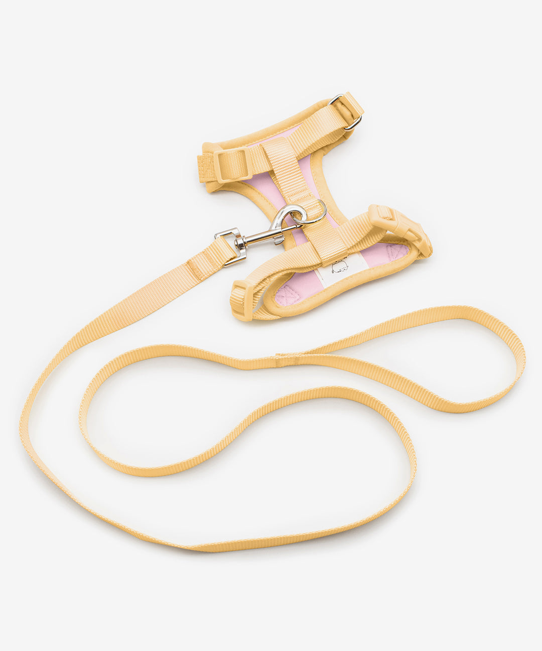 Pusheen Pet Yellow Harness & Leash Set on a white background. The detachable leash and lining of the harness is a yellow while the harness interior is light pink. The leash attaches to the harness via a silver hoop on top of the harness.