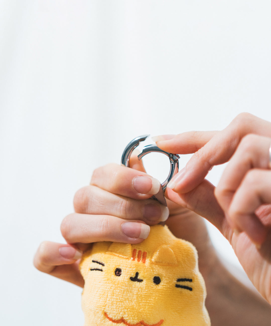Model holds open the metal keyring on the shrimp keychain. The keychain can be easily added to bags or keyrings. 