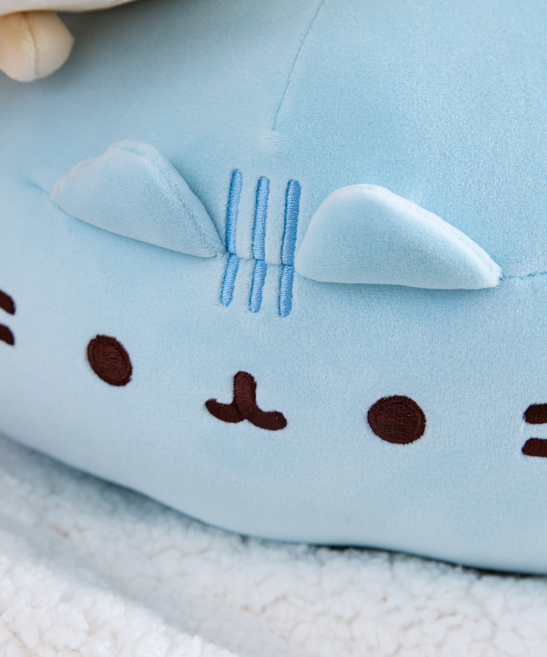 Close up of the embroidered face of the Blue Round Squisheen.