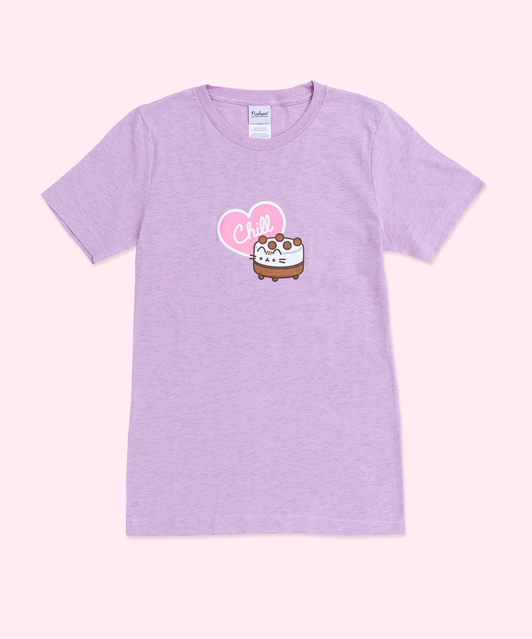 A light purple graphic short sleeve tee against a light pink background. The graphic in the center of the t-shirt features Pusheen as an ice cream cake accompanied by a pink and white heart with the phrase ‘Chill’ inside. 